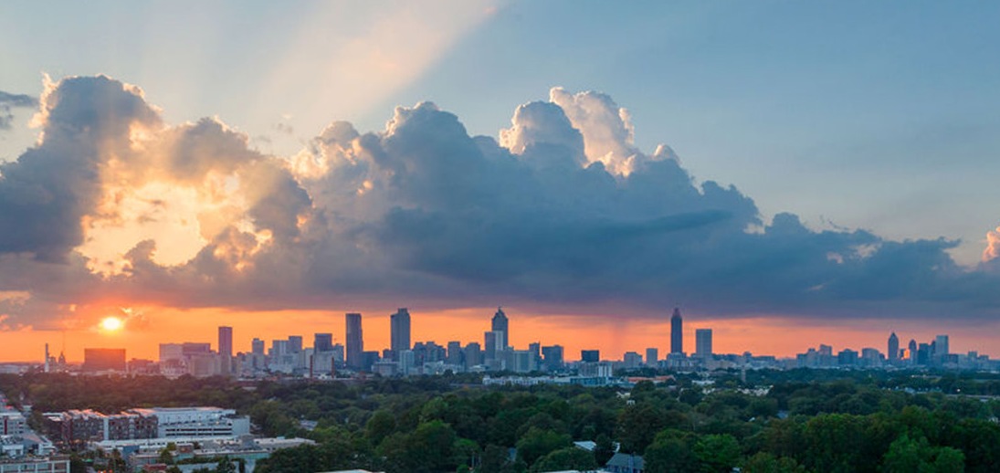 The Atlanta skyline at sunset over the residential neighborhoods where PortfolioLG lends